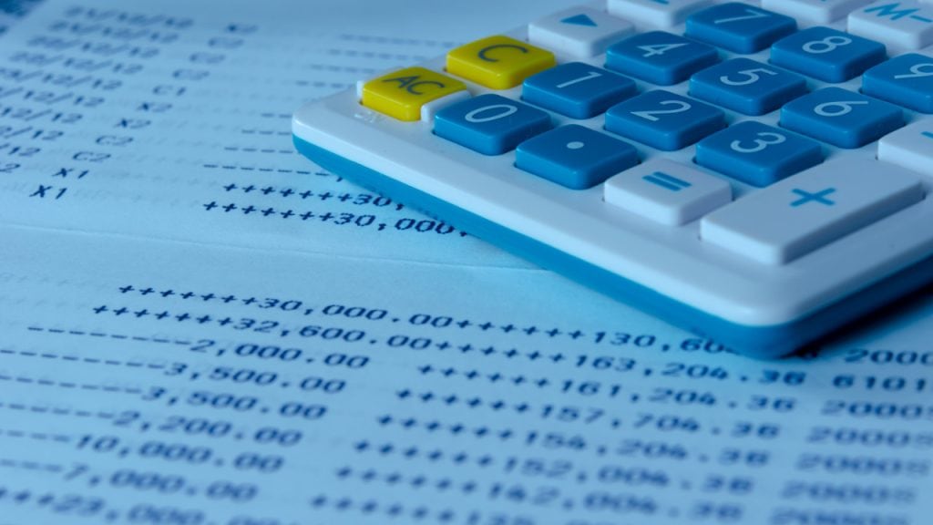 Calculator with blue and yellow keys on financial document, representing accounting and financial management services.