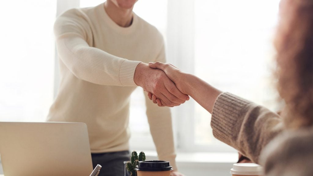 Professional business handshake between two individuals in a bright office setting, representing trusted accounting and financial services from GMS Accountants.