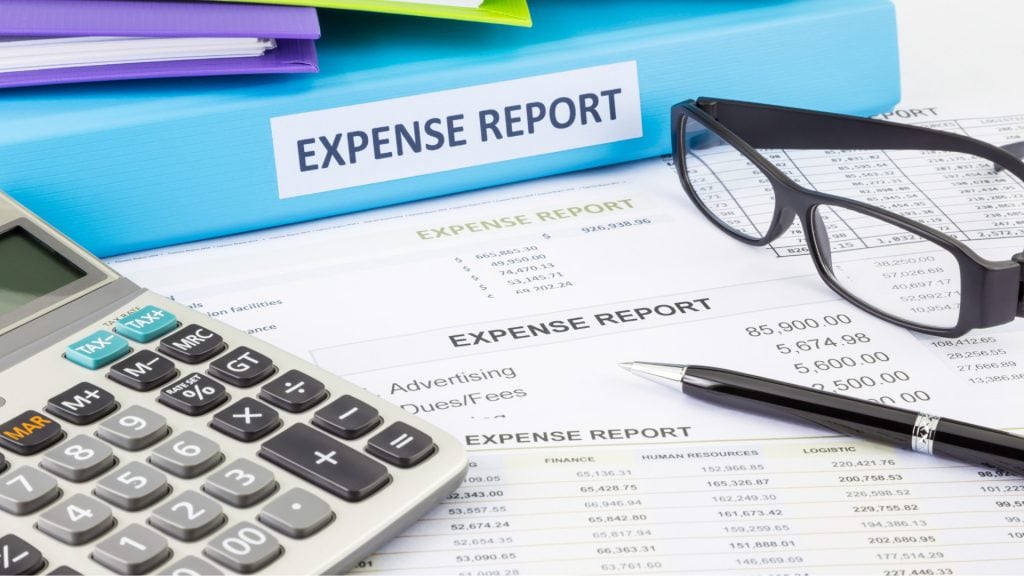 Detailed expense report with calculator, pen, and eyeglasses on financial documents, illustrating accounting, bookkeeping, and tax services offered by GMS Accountants in the UK.