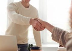 Professional business handshake between two individuals in a bright office setting, representing trusted accounting and financial services from GMS Accountants.