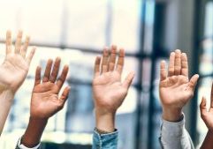 Diverse hands raised in a professional setting symbolising collaboration and inclusivity, representing GMS Accountants' commitment to personalised and accessible accounting services.