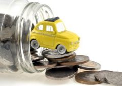 Bright yellow toy car atop a pile of mixed coins spilled from a glass jar, symbolising savings, financial growth, and affordable accounting services by GMS Accountants in the UK.
