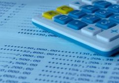 Calculator with blue and yellow keys on financial document, representing accounting and financial management services.