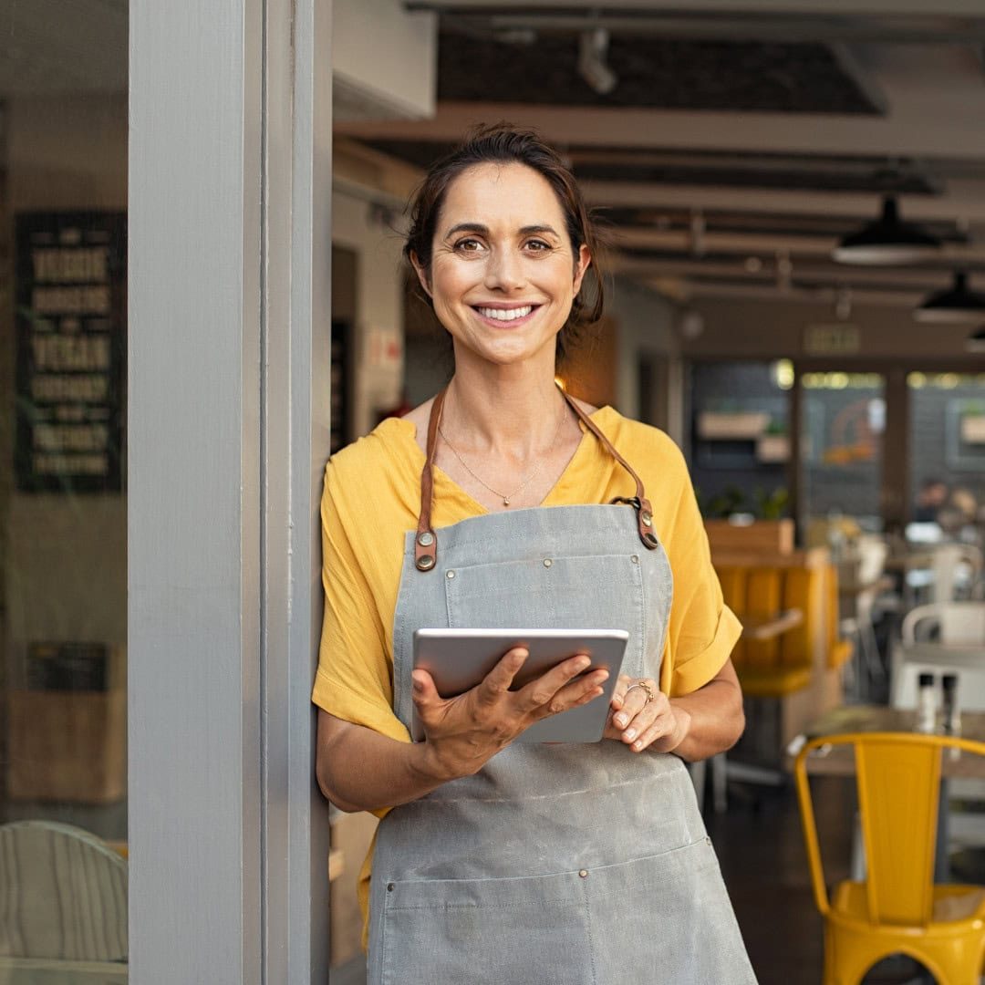 Professional woman in a cafe using a tablet, demonstrating business support.